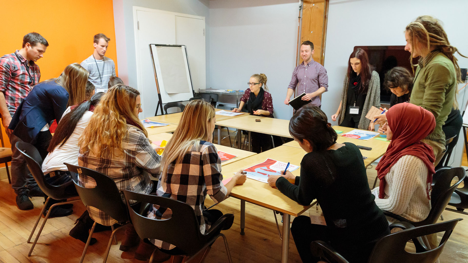 Group of people around a table writing on printouts